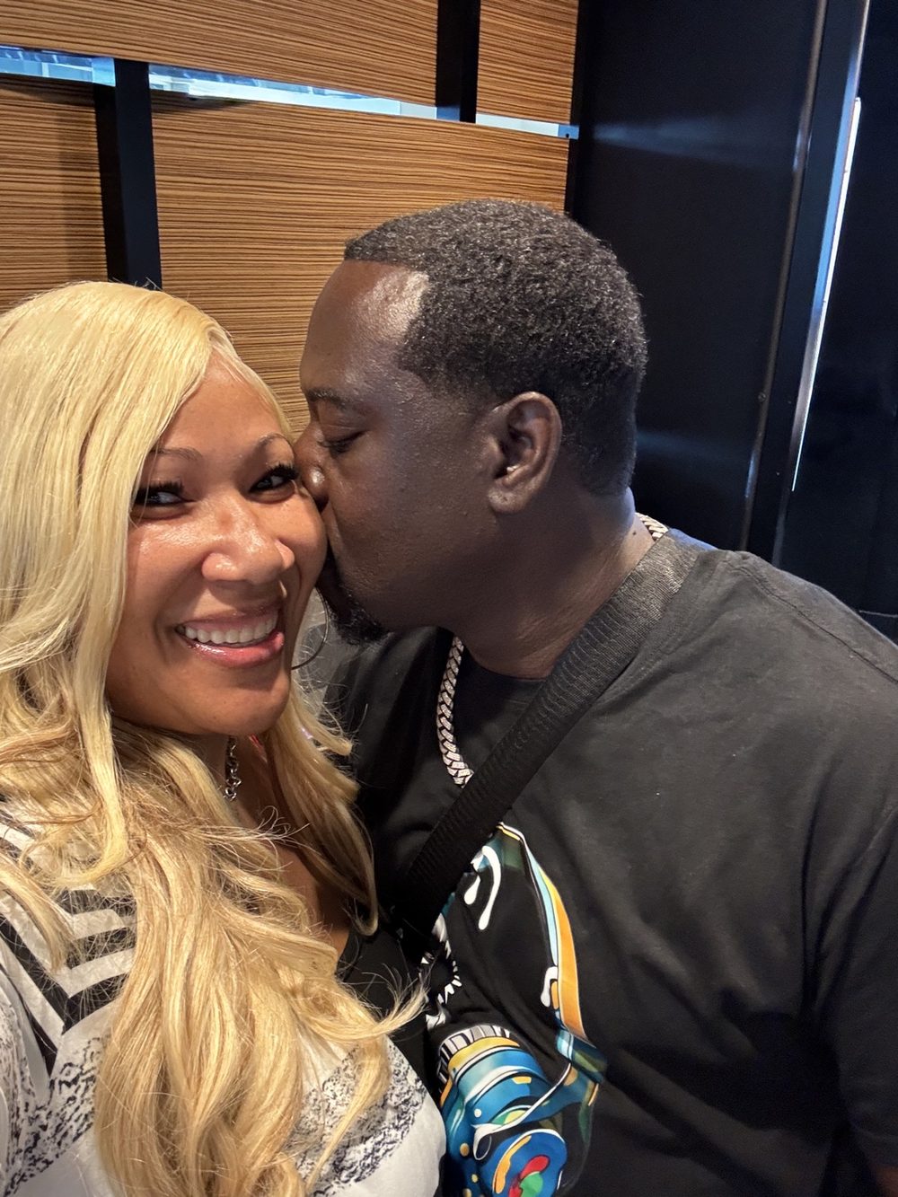 Dr. Judge smiling as her husband kisses her cheek