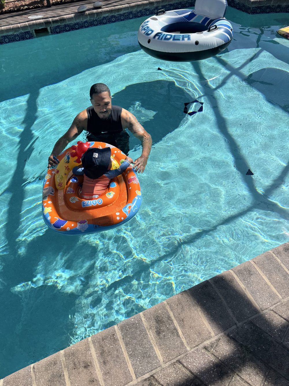 Pool day fun with dad and a toddler in a float